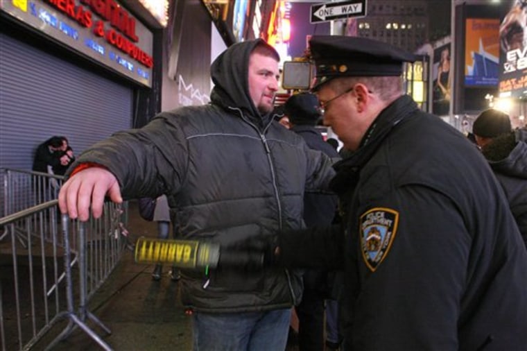 New York City police officer Michael Luciano, right, scans Brandon Caton, from Luray, Va., with a metal detector as he enters the crowd gathering in New York's Times Square to take part in the New Year's Eve festivities on Dec. 31, 2009. In the biggest public party in the country, nearly a million revelers will cram into the streets of Times Square to watch the ball drop on New Year's Eve. The party is also remarkably crime-free, safe and orderly. 